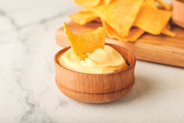 Hafif arka planda lezzetli nachos ve soslu pano, yakın plan.