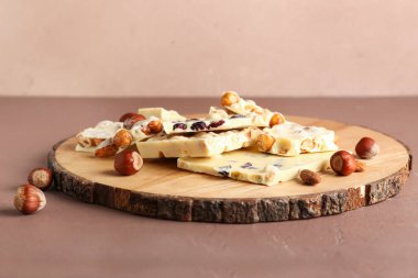 Tahta tahta tahta, beyaz çikolata ve fındık rengi arka planda.