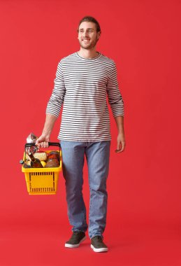 Arka planda alışveriş sepeti olan genç adam.