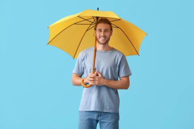 Renkli şemsiyeli yakışıklı genç adam.