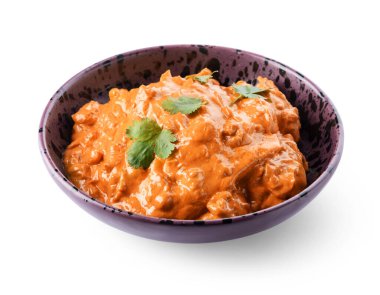 Beyaz arka planda bir kase lezzetli tavuk tikka masala.