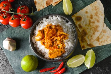 Bir kase lezzetli tavuk tikka masala ve pilav.
