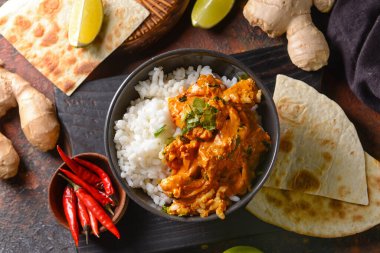 Bir kase lezzetli tavuk tikka masala ve pilav.