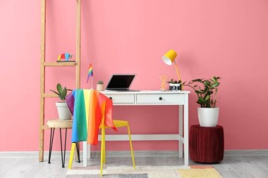 Sandalyesinde LGBT bayrağı asılı modern işyeri