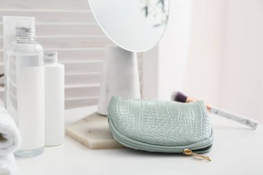 Odada dekoratif kozmetik ürünleri olan şık bir çanta.