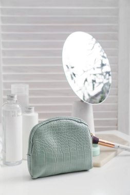 Odada dekoratif kozmetik ürünleri olan şık bir çanta.