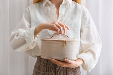 Hafif arka planda kozmetik çantalı kadın