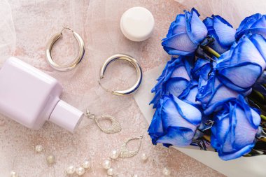 Güzel mavi güller, parfüm ve parlak arka planda mücevherler.