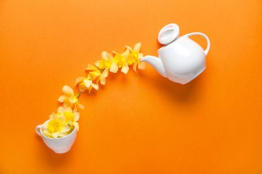 Güzel nergis, çaydanlık ve renkli fincanla yaratıcı kompozisyon