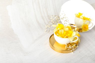 Hafif arka planda güzel nergisler olan bir fincan.