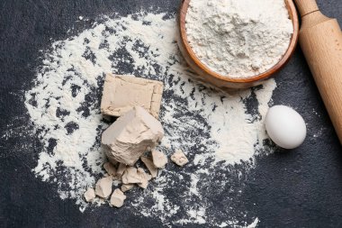 Koyu arkaplanda taze maya ve un.