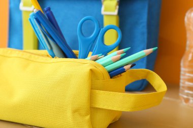 Renkli arka planda kırtasiye ve sırt çantalı kalem kutusu