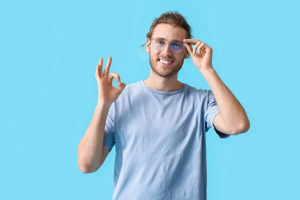 Mladý Muž Nosí Brýle Ukazuje Barevném Pozadí — Stock fotografie