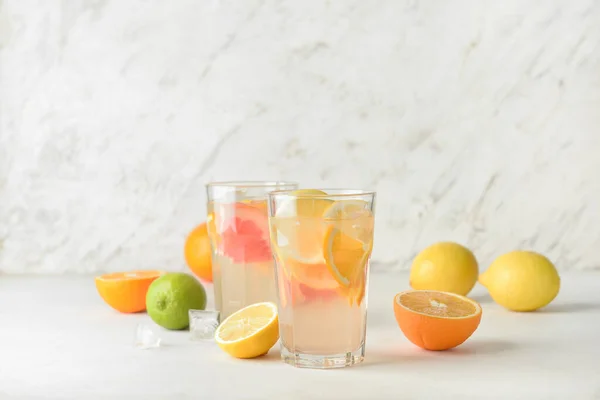 Gläser Mit Schmackhafter Kalter Limonade Und Zitrusfrüchten Auf Hellem Hintergrund — Stockfoto
