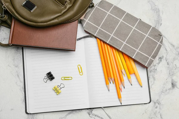 Pencil case and stationery on light background