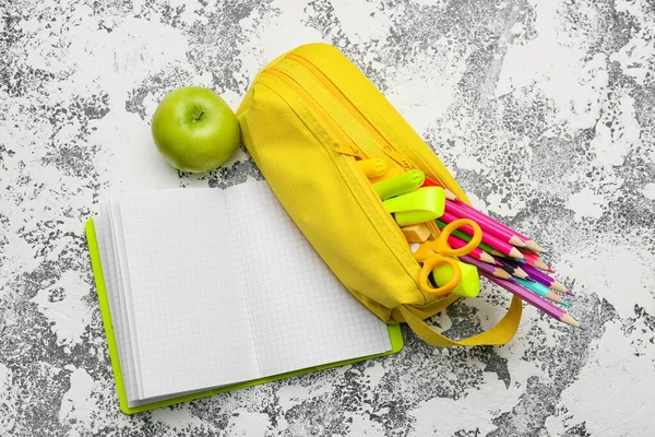 Pencil case and stationery on grunge background