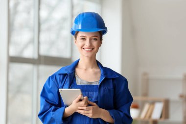 Odada tablet bilgisayarı olan güzel bir kadın elektrikçi.