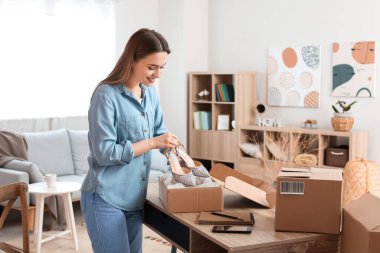 Müşteri için paket hazırlayan genç bir kadın.