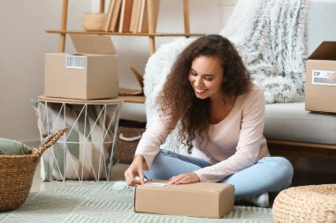 Müşteri için paket hazırlayan genç bir kadın.