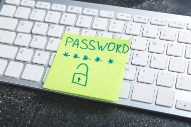 PC klavye ve üzerinde PASSWORD yazıları olan kağıt. Hackleme kavramı