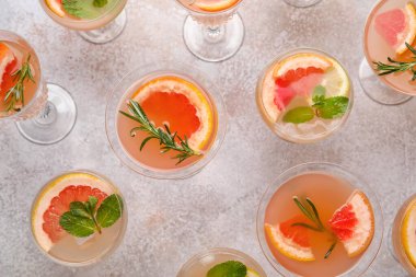 Gri arka planda bir bardak lezzetli greyfurt kokteyli