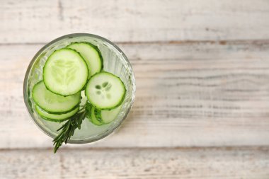 Hafif ahşap arka planda salatalıklı limonata.