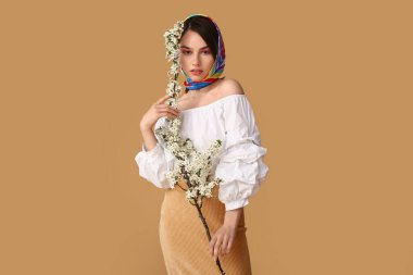 Renkli arka planda çiçek açan bahar dalları olan güzel genç bir kadın.