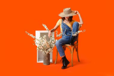 Renkli arka planda çiçek açan bahar dalları olan güzel genç bir kadın.