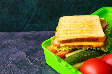 Koyu arkaplanda lezzetli yemekler olan beslenme çantası.