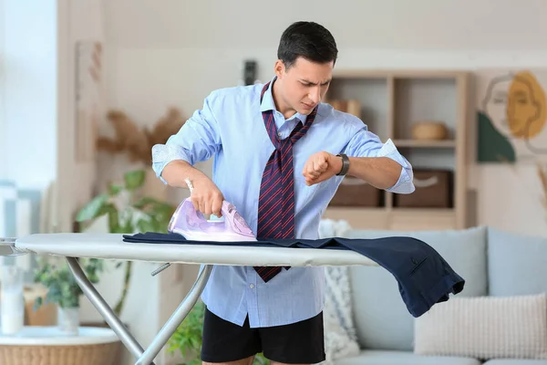 Young Man Looking Wristwatch While Ironing Clothes Home — Stock Photo, Image