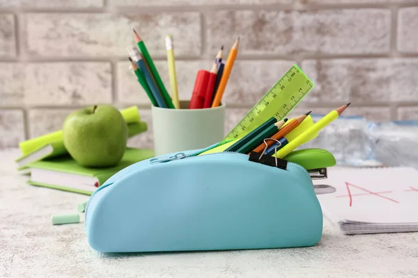 Pencil case with stationery on light table