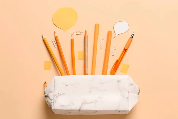 Pencil case and stationery on color background