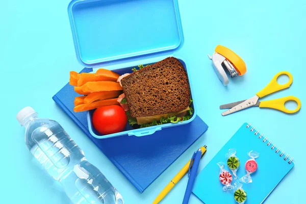 Lunchbox Mit Leckerem Essen Und Schulpapier Auf Farbigem Hintergrund — Stockfoto