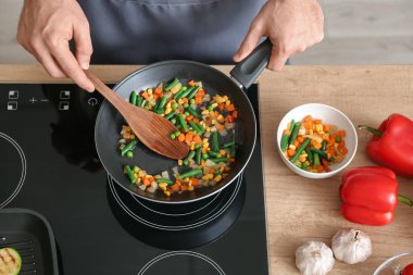 Mutfakta sebze kızartan adam, yakın plan.