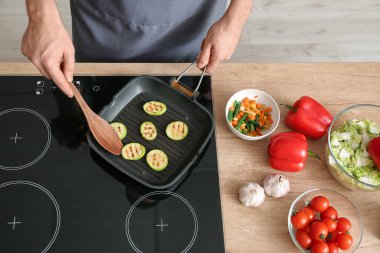 Mutfakta sebze kızartan adam, yakın plan.