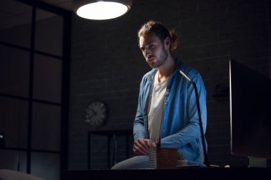 Akşam geç saatlerde evde çalışan yakışıklı bir adam.