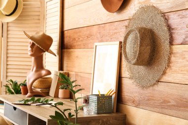 Manken ve ahşap duvarın yanında şapkası olan şık bir iş yeri.