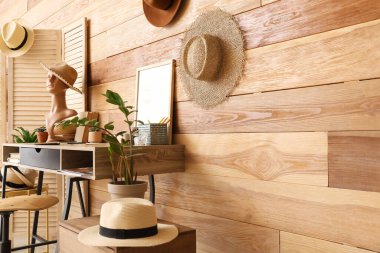 Manken ve ahşap duvarın yanında şapkası olan şık bir iş yeri.