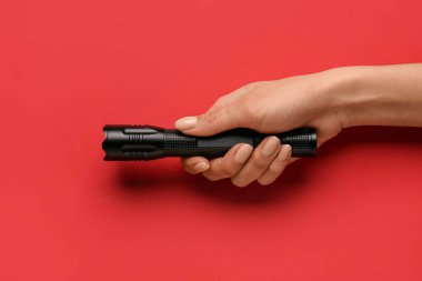 Renkli arka planda modern el feneri olan kadın eli