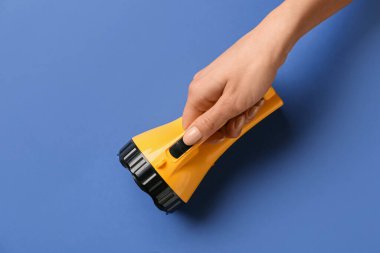 Renkli arka planda modern el feneri olan kadın eli