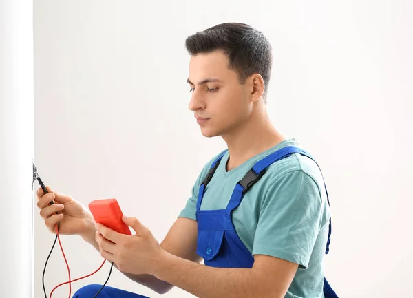 Young Electrician Measuring Voltage Socket Room — Stock Photo, Image