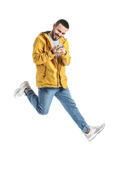 Springender Junger Mann Mit Handy Auf Weißem Hintergrund — Stockfoto