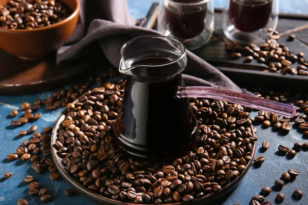 色の背景に熱いコーヒーと豆のポット — ストック写真
