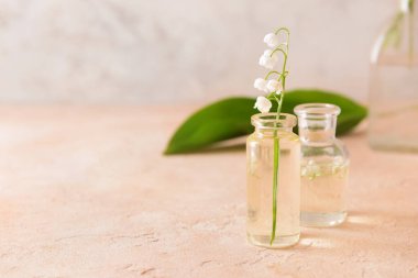 Gerekli yağlı şişeler ve arka planda zambak çiçekleri.