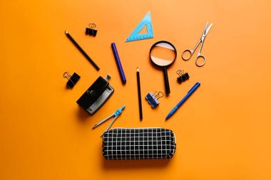 Renk arkaplanında kırtasiye malzemesi olan kalem kutusu