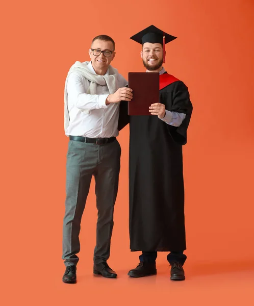 Glücklicher Männlicher Abschlussschüler Mit Seinem Vater Auf Farbigem Hintergrund — Stockfoto