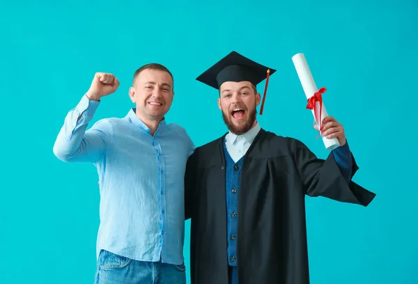 Heureux Mâle Graduation Étudiant Avec Son Père Sur Fond Couleur — Photo