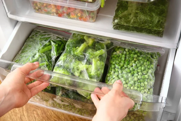 冷蔵庫で野菜と女性の手やビニール袋 — ストック写真