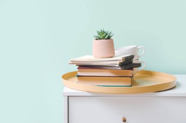 Sulu, çekmeceler üzerine kitap ve fincanlar.