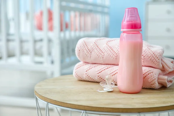 Бутылка Молока Малыша Пустышкой Одеждой Столе — стоковое фото